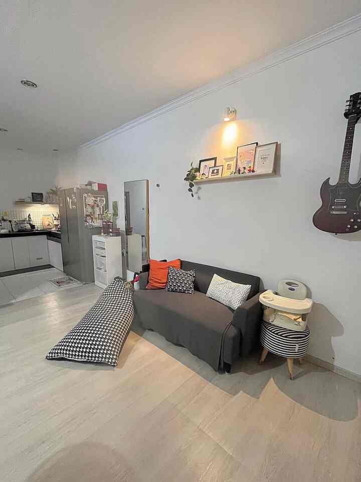 White walled open living room with gray sofa and black-and-white bean bag seating