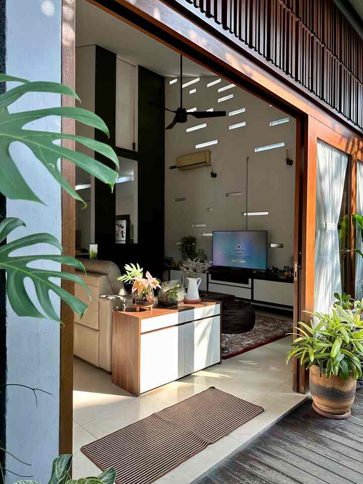 Modern and simple living room with white and wood tones connected to a veranda, featuring sofa and TV stand