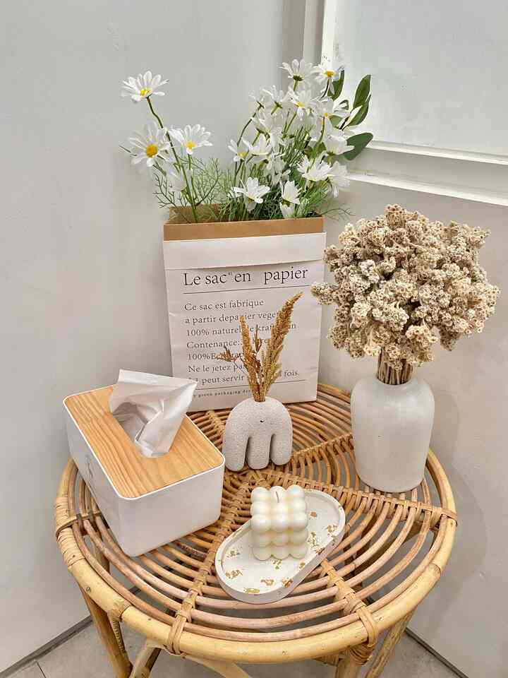 White and wood-tone living room corner featuring a rattan table with natural decor items creating a cozy atmosphere