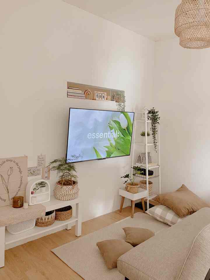 Small living room in white and beige tones featuring a sofa bed and plants with a natural atmosphere