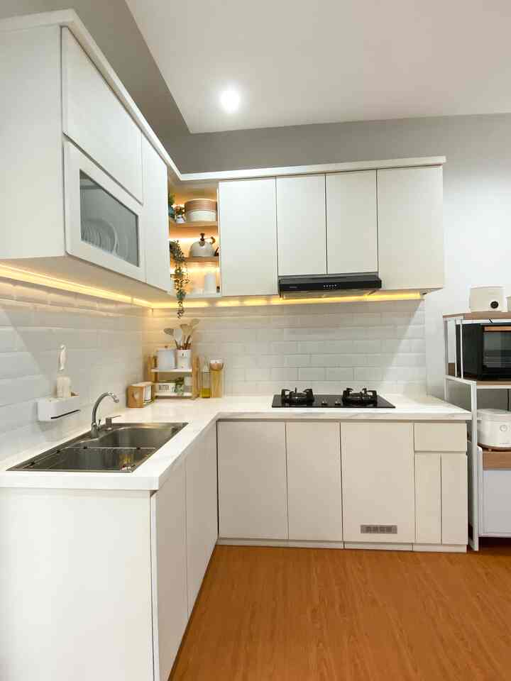 Japandi style kitchen with white cabinetry and wood-tone flooring, featuring warm yellow lighting for a cozy atmosphere