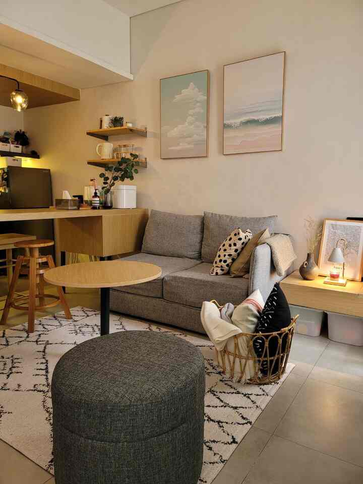 Beige and wood tone living room featuring gray sofa and round coffee table in a natural modern style space