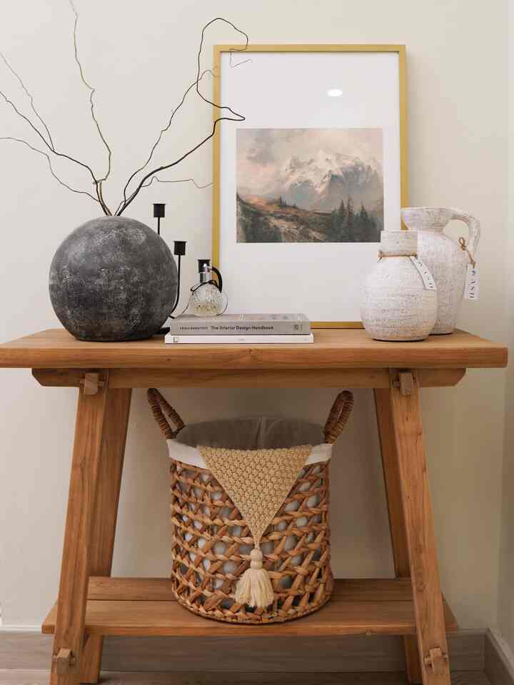 Natural-toned entrance featuring wooden console table with various objets creating a cozy atmosphere