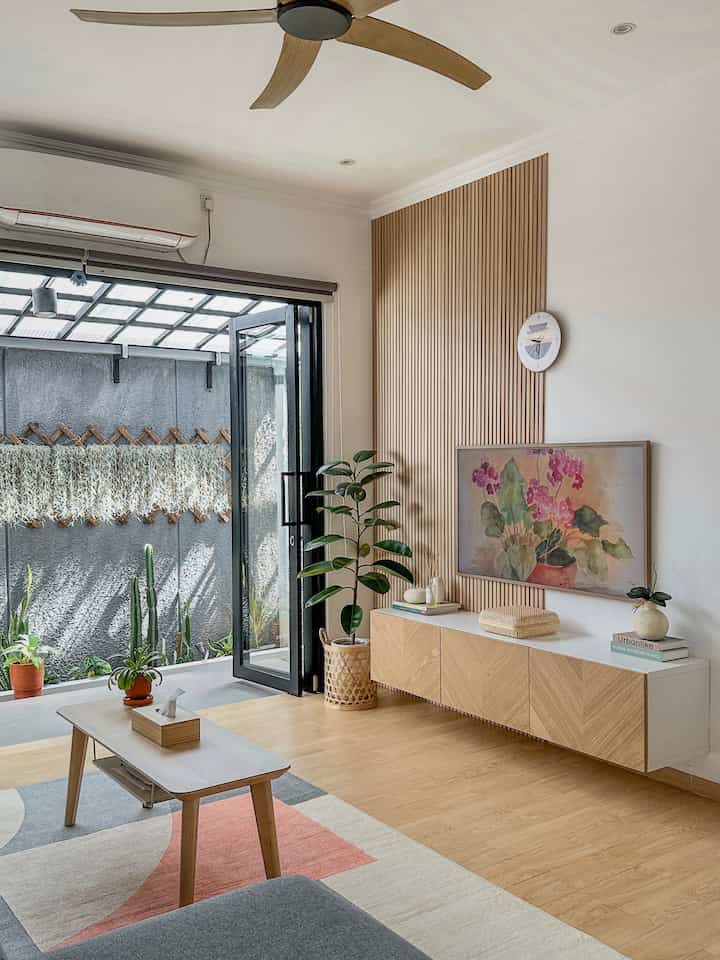 Bright wood tone and white living room featuring plants and coffee table with natural and cozy atmosphere