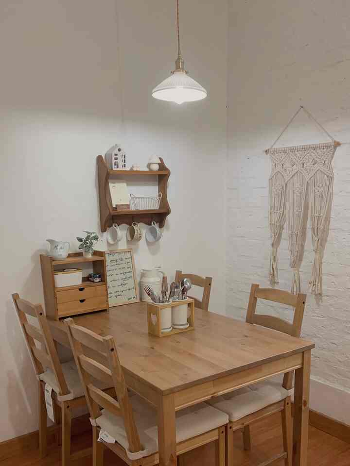 Dining room with white walls and wood tone dining table with four chairs in a natural Japandi style