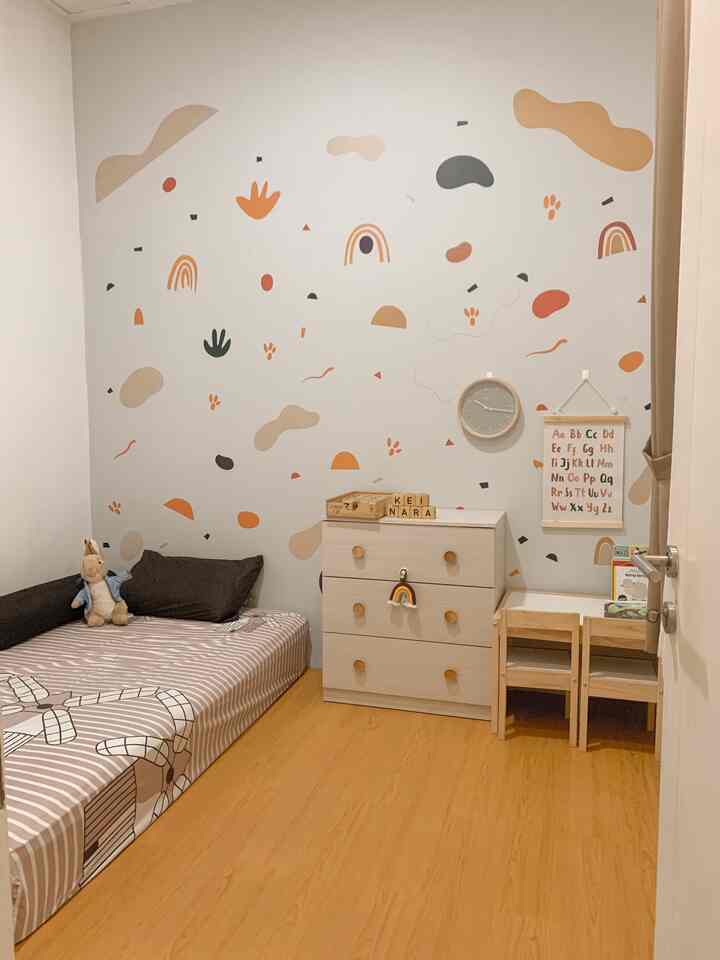 A cozy kids' room in white and wood tones featuring a child’s bed, desk, and educational poster on the wall