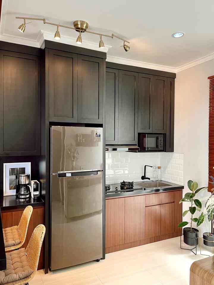 Black and brown toned kitchen space featuring custom upper and lower cabinets with a modern natural feel