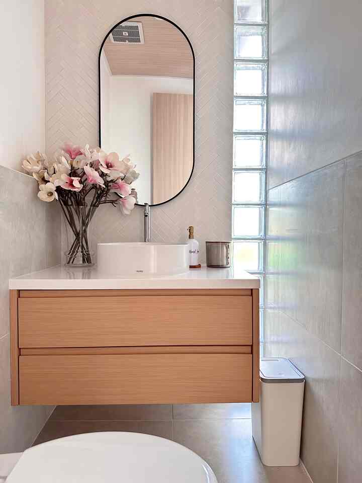 Natural-toned bathroom featuring wooden vanity and white wash basin with a clean and simple design