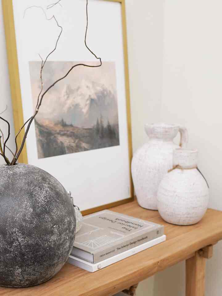 Natural-toned entrance space featuring gold picture frame and natural wood table decor with warm atmosphere