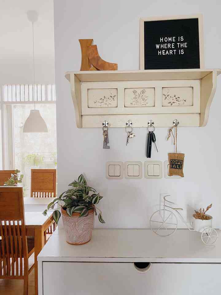 White and wood tone entrance space featuring storage shelf and plants with cozy atmosphere