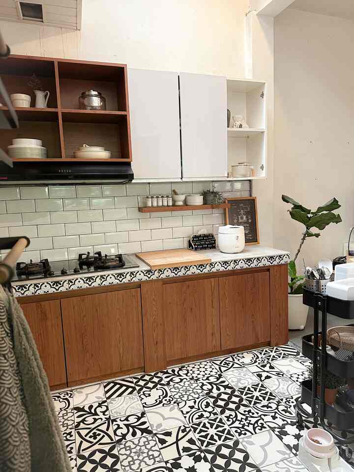 Mau cerita, awal nempatin rumah dapurnya sudah settingan kompor tanam jd kami tinggal beli kompor dg size sesuai lobang meja dapur. 
Sdikit makeover yg kami buat biar dapur lawas ini spy lebih stylish spt:
1. Keramik meja dapur yg menguning ditutup lapisan pvc anti air anti minyak, namanya kertasive. Dipilih motif ala semen wrn terang unt mengimbangi lis meja dapurnya.
2. Lis meja dapur awalnya keramik motif buah2an 😅 ditutup stiker motif tegel yg dipesan custom. Fyi ini stiker awet banget udh 11th nempel 🤭
3. Pasang backsplash dg keramik bevel size 10x20
4. 2th lalu kami bongkar vynil dapur yg udh pd ngelupas ganti jd pasang lantai tegel. Lgs ditimpa aja ke keramik lama yg tdnya wrn kekuningan.
Dan lantai tegel ini jd focal point di dapur ini .. setuju? 
.
.
#kitchenstyling #kitchendecorideas #kitchenmakeover #homeinspo #homedecor #inspirasidapur #makeoverlowbudget 