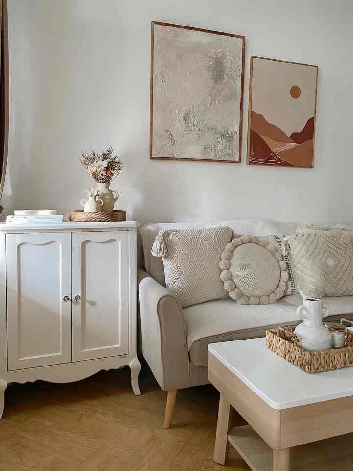 Beige and white toned living room featuring a baroque-style white cabinet and cushioned sofa creating a warm, cozy atmosphere