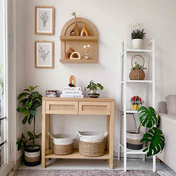 Natural-colored minimal entrance space featuring wood tone console table, plants, and woven storage baskets with a cozy atmosphere
