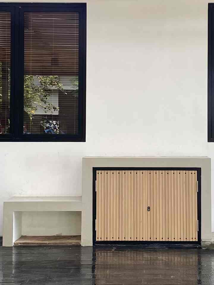 Beige and white toned outdoor carport featuring wood-tone cabinet with simple and practical design