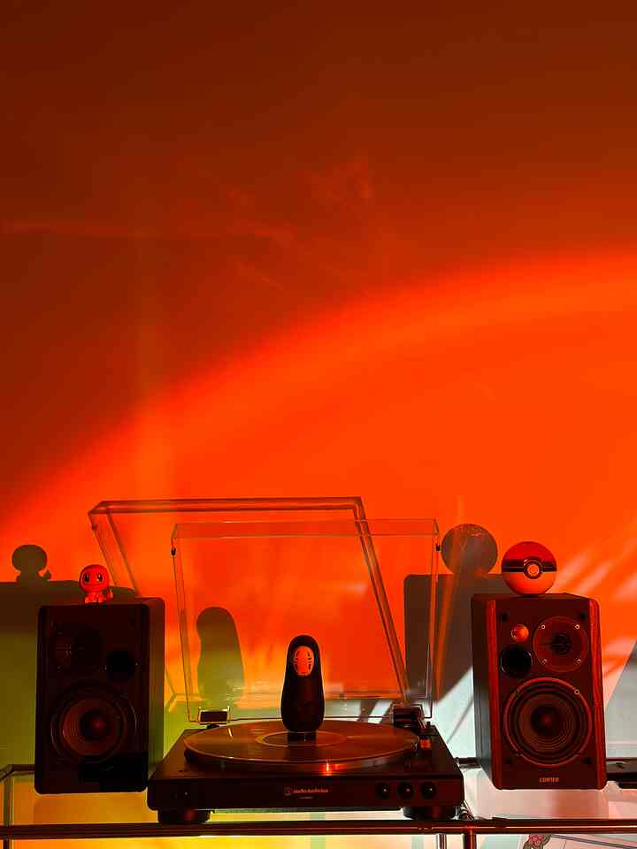 Warm orange-toned corner space featuring an Audio-Technica turntable and Edifier speakers, creating a minimal and retro home cafe atmosphere