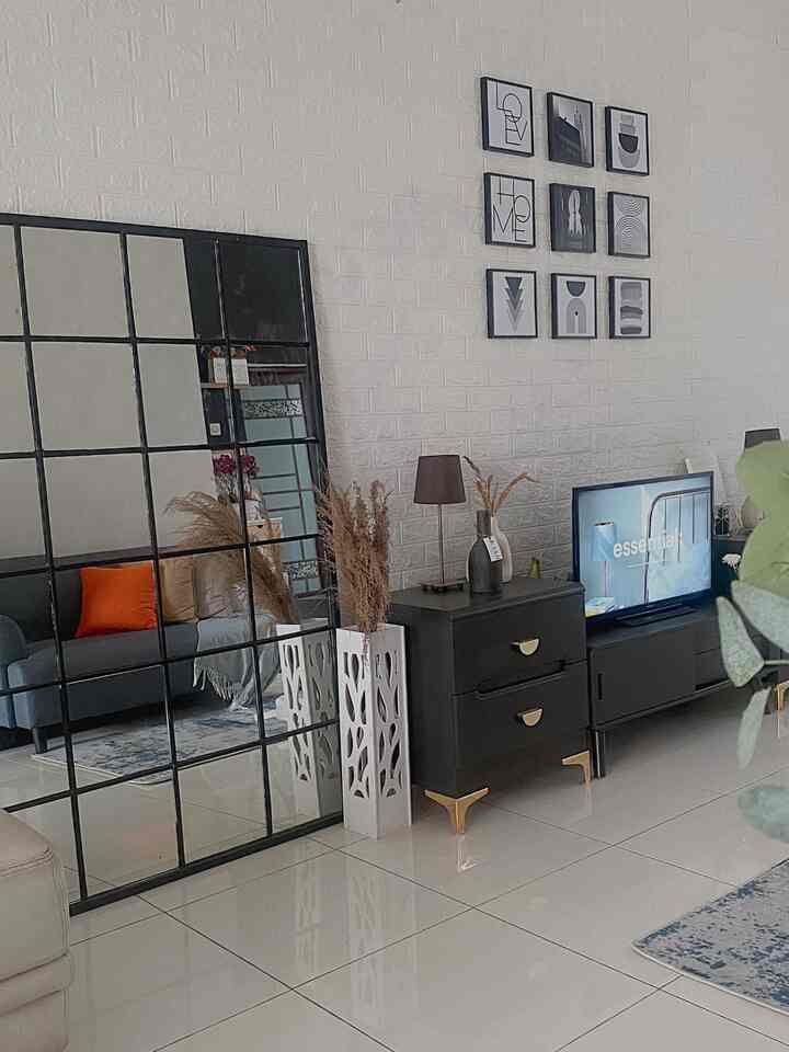 Minimal living room featuring black furniture with gold accents and wall art