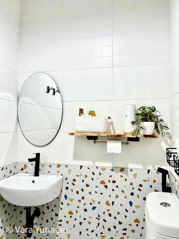White and terrazzo patterned bathroom featuring a wooden shelf with a plant, creating a clean and modern ambiance