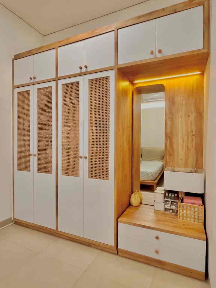 White and wood tone bedroom closet featuring simple, natural Japandi style elements with built-in storage and mirror