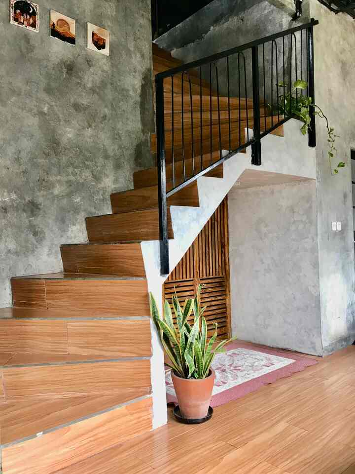 Area Tangga yang bersebelahan dengan ruang tamu. Tidak banyak ornamen agar memudahkan area lalu lalang. Tanaman hijau tetap menjadi hiasan yang membuat kesan Homey 

#rumahdeveloper
#rumahsibsidi
#bogor
#tangga #stairs #lantai2 