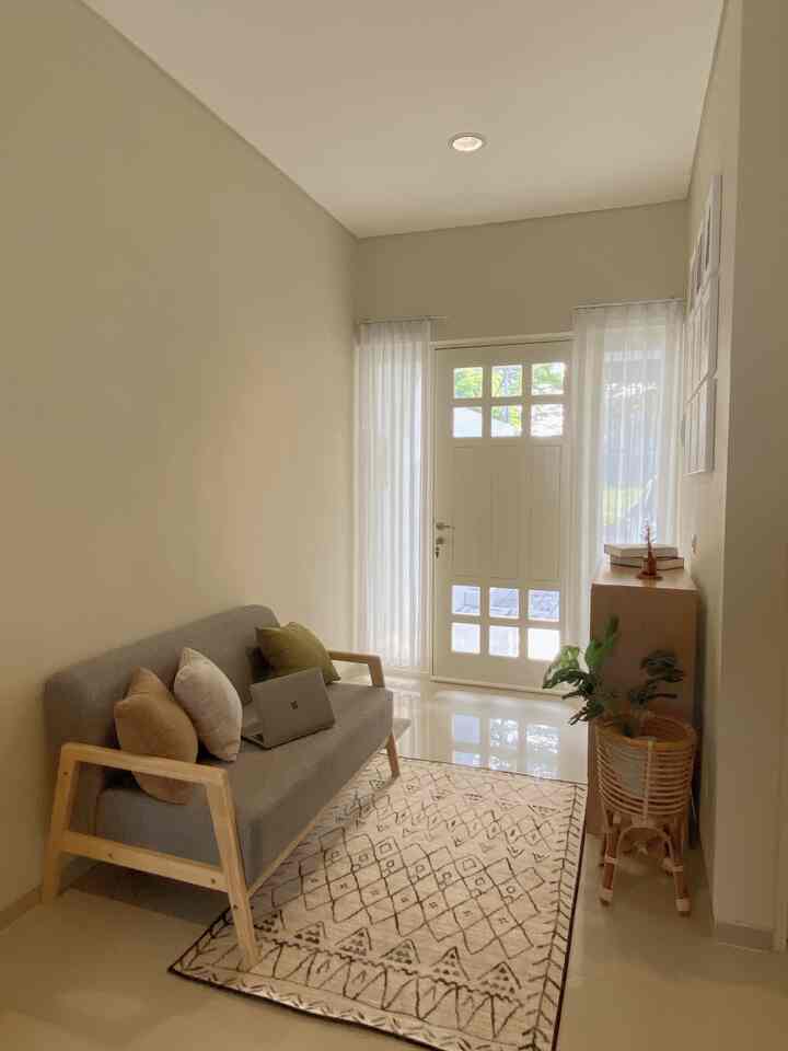 Beige and wood tone narrow long living room featuring minimalist sofa and rug with cozy atmosphere.