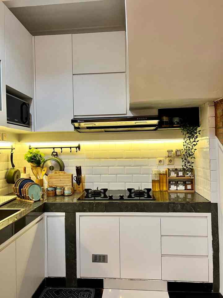 Modern kitchen in white and black tones with clean storage and neatly arranged kitchen utensils for a functional space