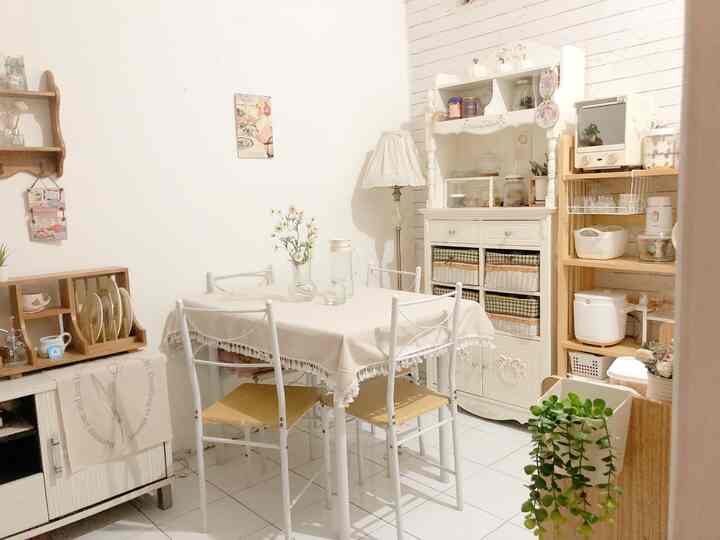 Bright white and natural toned small dining room featuring a dining table and chairs with storage units creating a cozy atmosphere