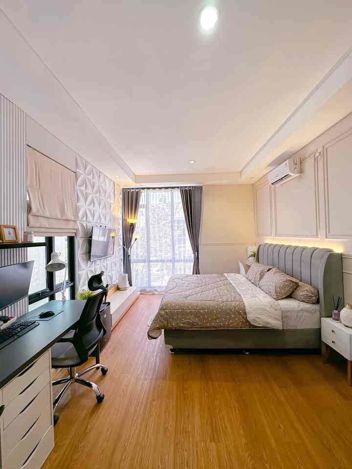 A modern bedroom in beige and wood tones featuring a bed and desk, creating a cozy hotel-like atmosphere