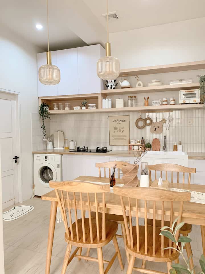 White and natural toned kitchen featuring wooden dining table and chairs with a warm and cozy atmosphere