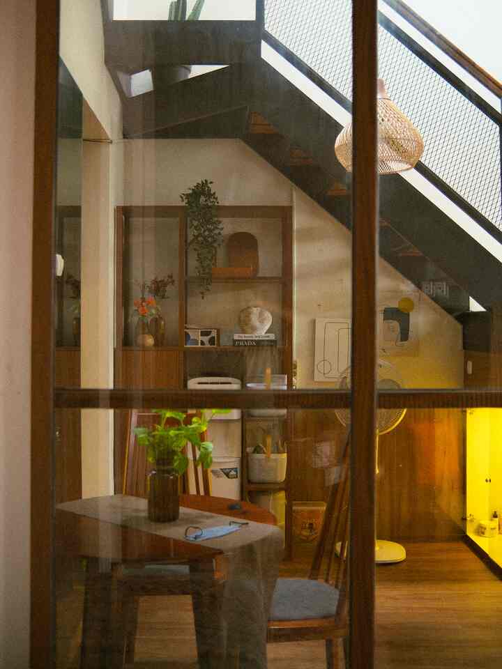 Bohemian style kitchen and dining room featuring wood tones and an industrial staircase with warm lighting