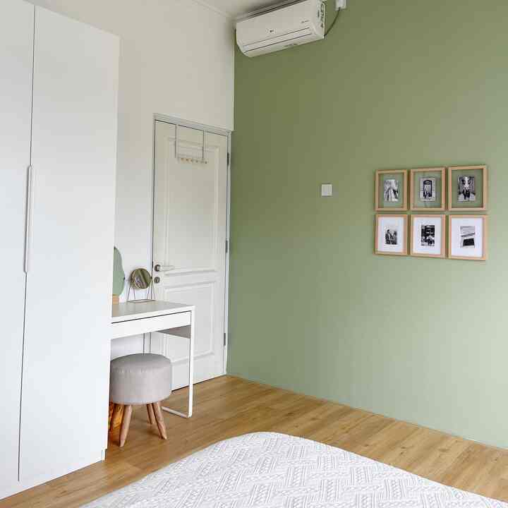 Natural-colored bedroom featuring white furniture and green wall art, creating a clean and cozy atmosphere