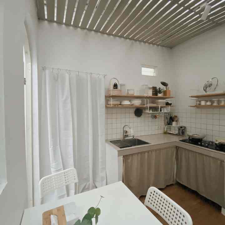 White and beige toned kitchen space featuring a curtain room divider with a simple interior design