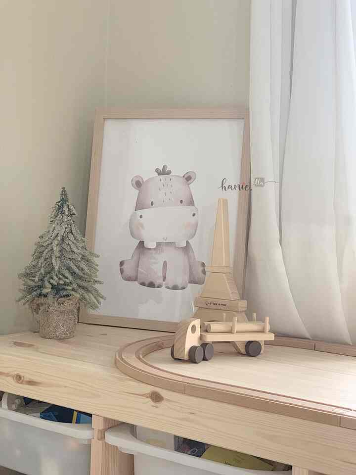 Natural tone kids' room with beige walls and white curtains, featuring wooden toys and a cute animal picture frame in a cozy setting