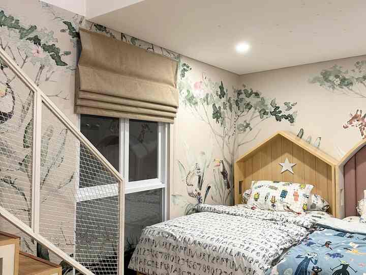 Wood tone and white themed loft-style kids' room with nature-inspired wallpaper and staircase, creating a cozy natural atmosphere