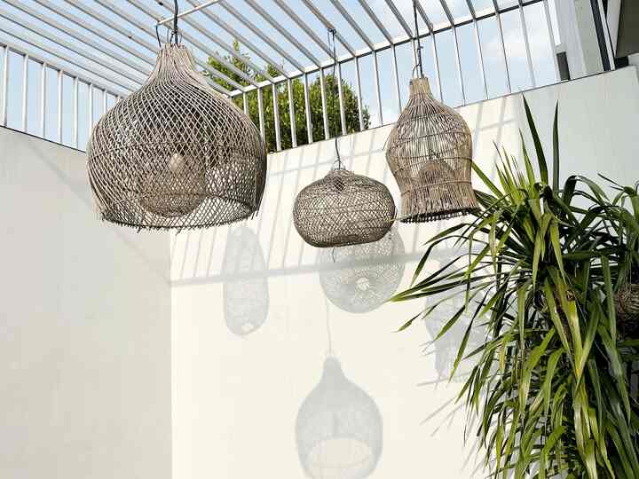 Natural color balcony space with pendant lights, featuring green plants blending for a serene atmosphere