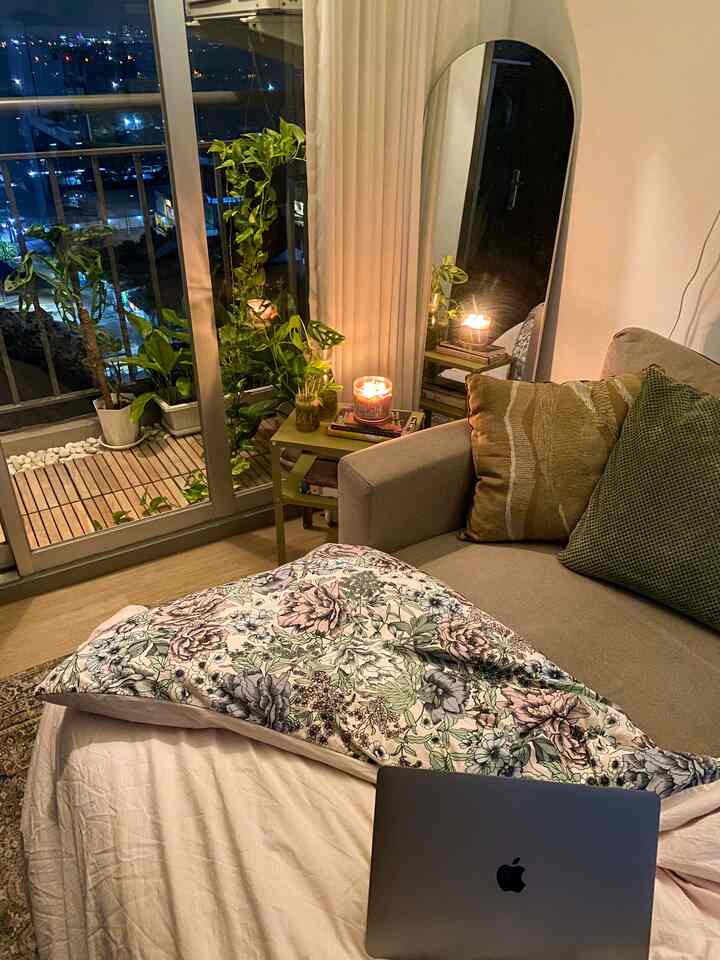 Natural toned living room cozy nook with warm mood lighting and lush green plants
