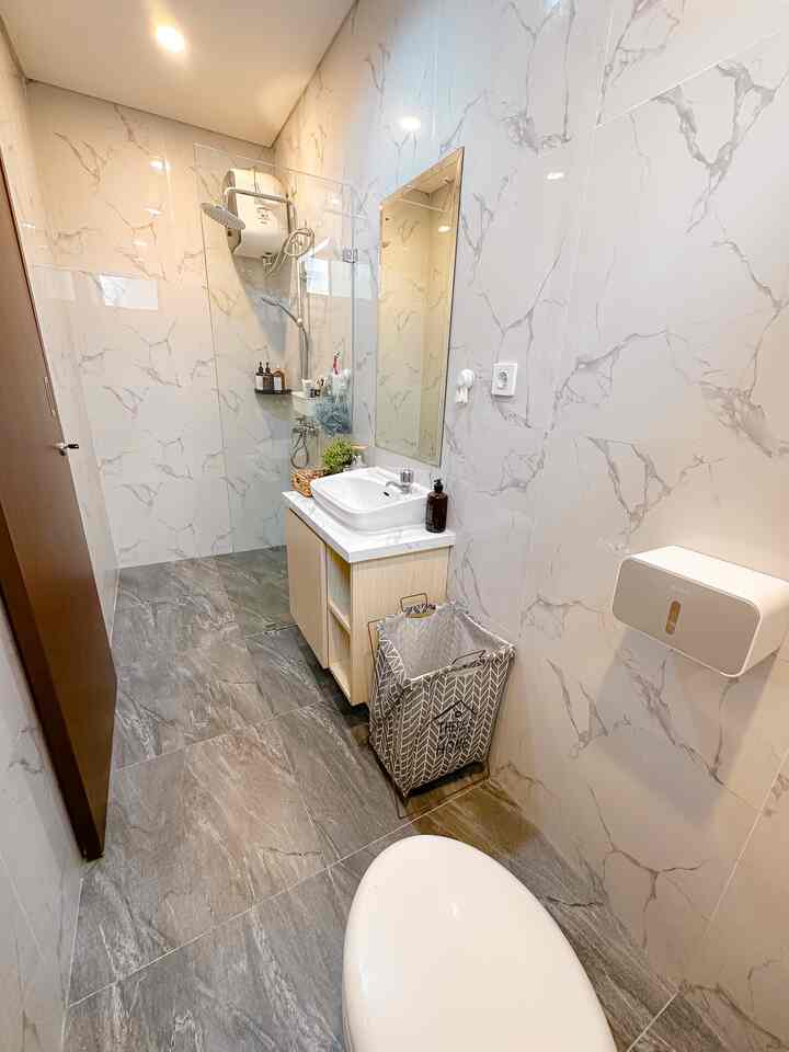 White and gray toned narrow long restroom featuring sink and sliding door in a modern layout