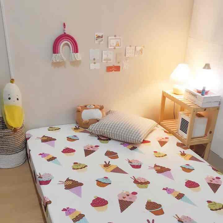 Beige-toned kids' room featuring baby bed and natural wooden shelf with a warm and cozy atmosphere