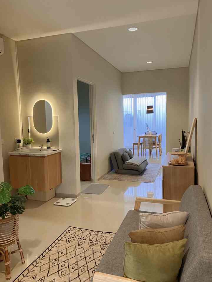 Natural tone and wood-toned long living room featuring a gray sofa and wooden dining table with cozy atmosphere