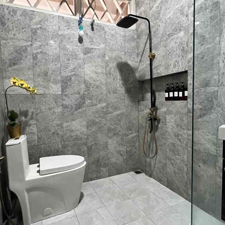 Monotone bathroom with gray marble tiles and black shower column, featuring a simple and modern atmosphere