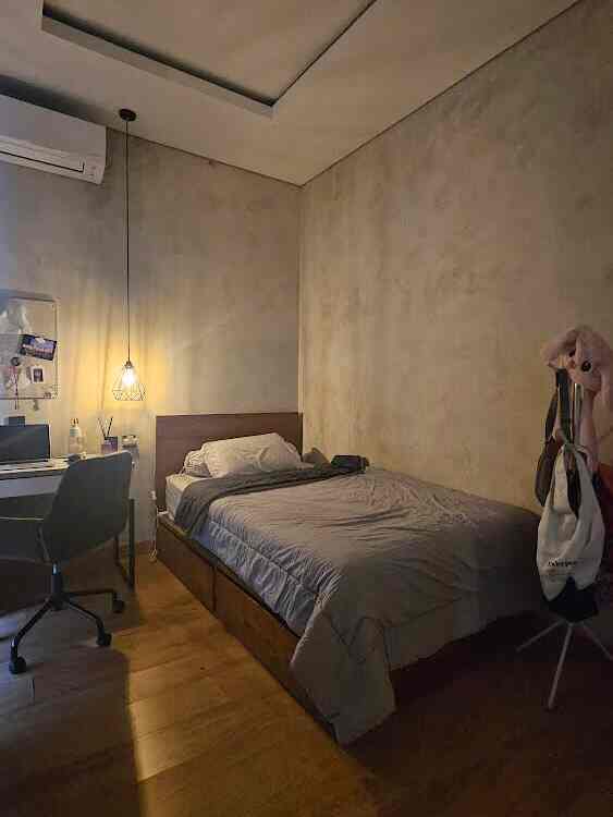 Gray and wood tone industrial style kids' bedroom featuring a bed, desk, and pegboard with cozy atmosphere