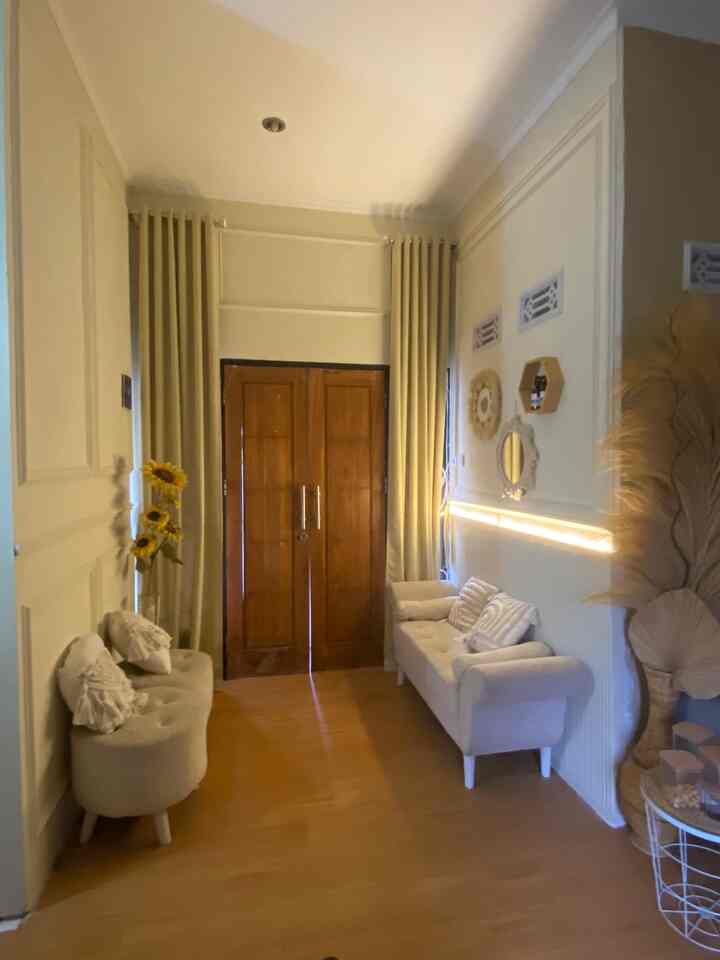 Beige and wood tone small entrance living room featuring two sofas and curtains, creating a warm and cozy atmosphere