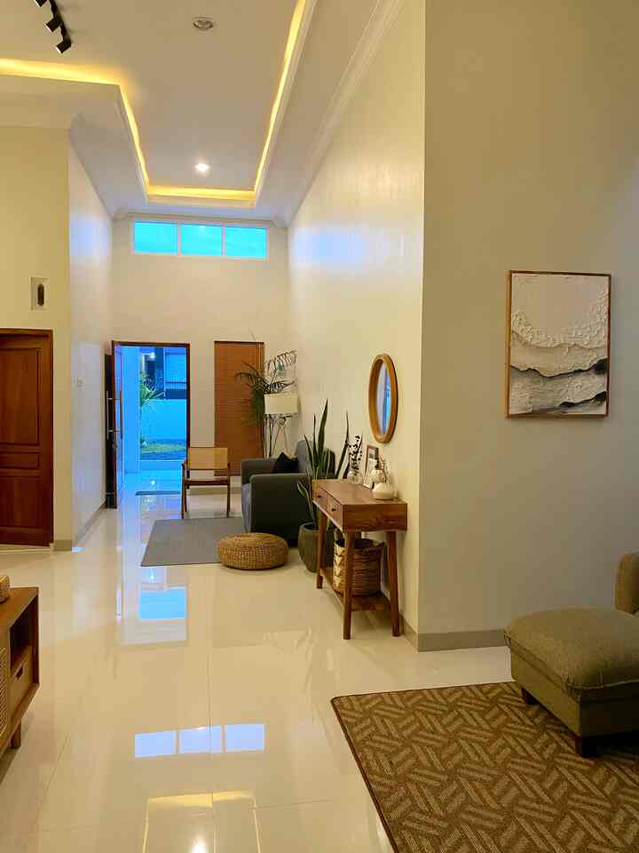 A natural-toned living room featuring wooden furniture, plants, and an open, spacious atmosphere