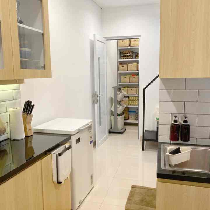 A narrow, long kitchen in white and wood tones featuring pantry storage and smart organization, creating a clean interior atmosphere