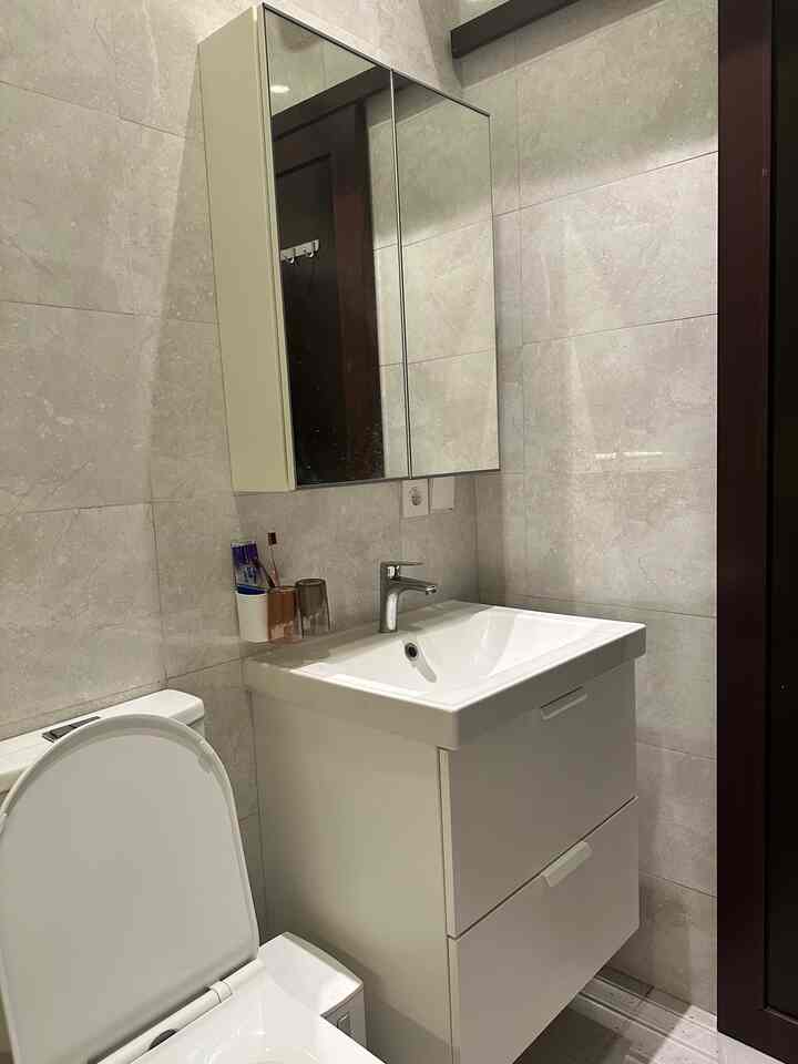 White and gray toned bathroom featuring a sink cabinet with mirror cabinet above, creating a clean and simple atmosphere