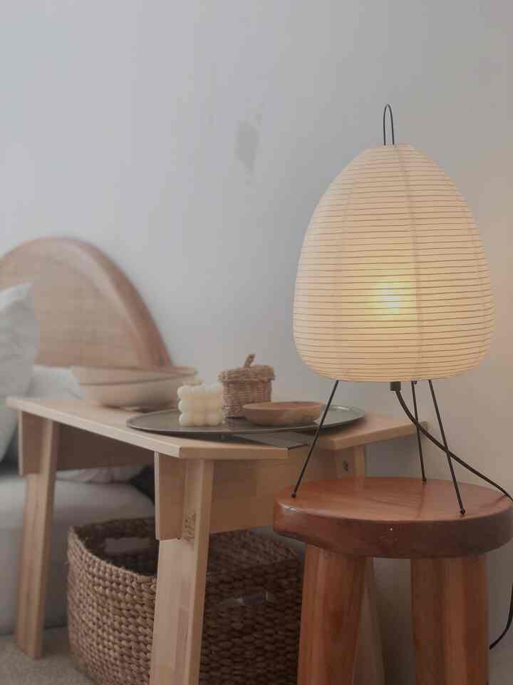 Natural toned bedroom featuring wooden furniture and an Akari table lamp providing soft ambient lighting