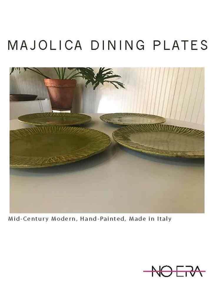 Mid-century modern setting with four pale green dining plates on a clean white table against a natural-toned wall