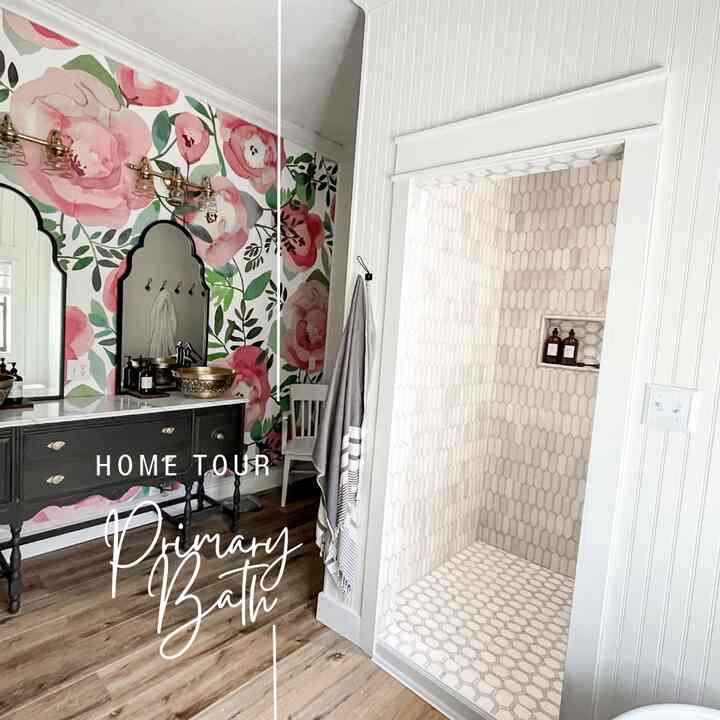 This primary bath is a "girly girls" dream with a beautiful pink floral wallpaper sprinkled throughout. The shower walls are clad with marble as well as gorgeous marble flooring beneath the stand alone bathtub. There are just so many details that really make this modern farmhouse bathroom pop. #modernfarmhouse #primarybath #marblebath