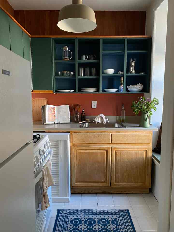 Natural tone kitchen with wooden lower cabinets and blue upper shelves, creating a cozy atmosphere