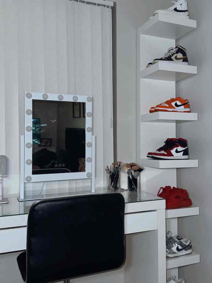 White-toned bedroom featuring a vanity desk with mirror and shoe shelves creating a neat, streamlined space