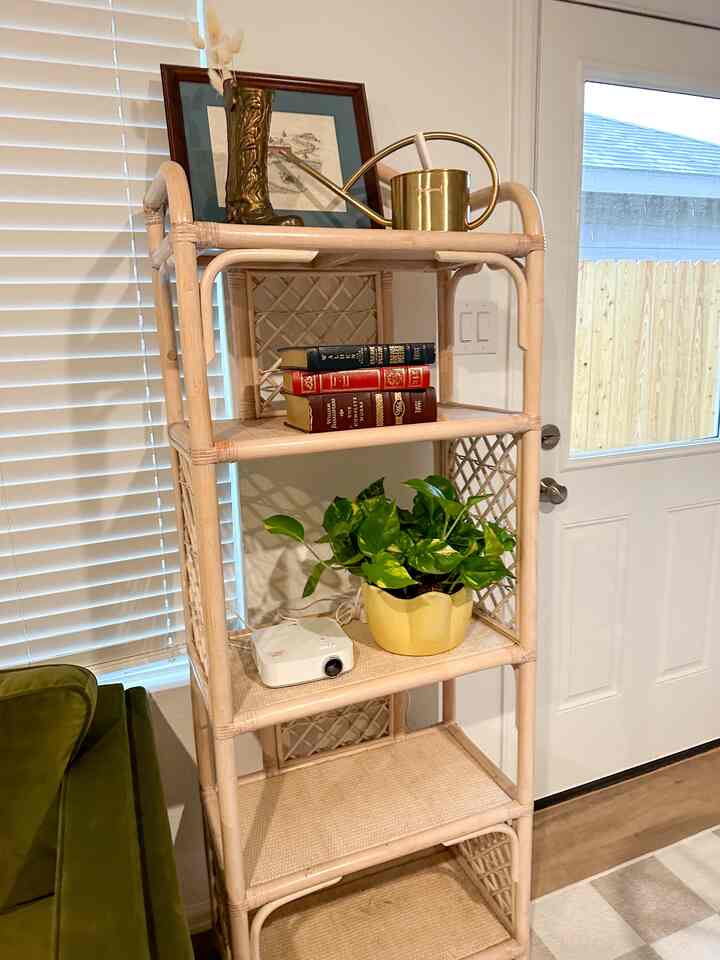 Cozy living room featuring a green sofa and rattan shelving with natural warm tones